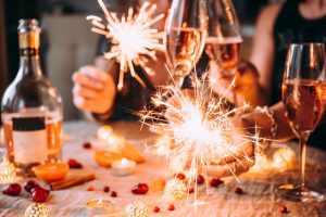 people celebrating with champagne and sparklers at a table
